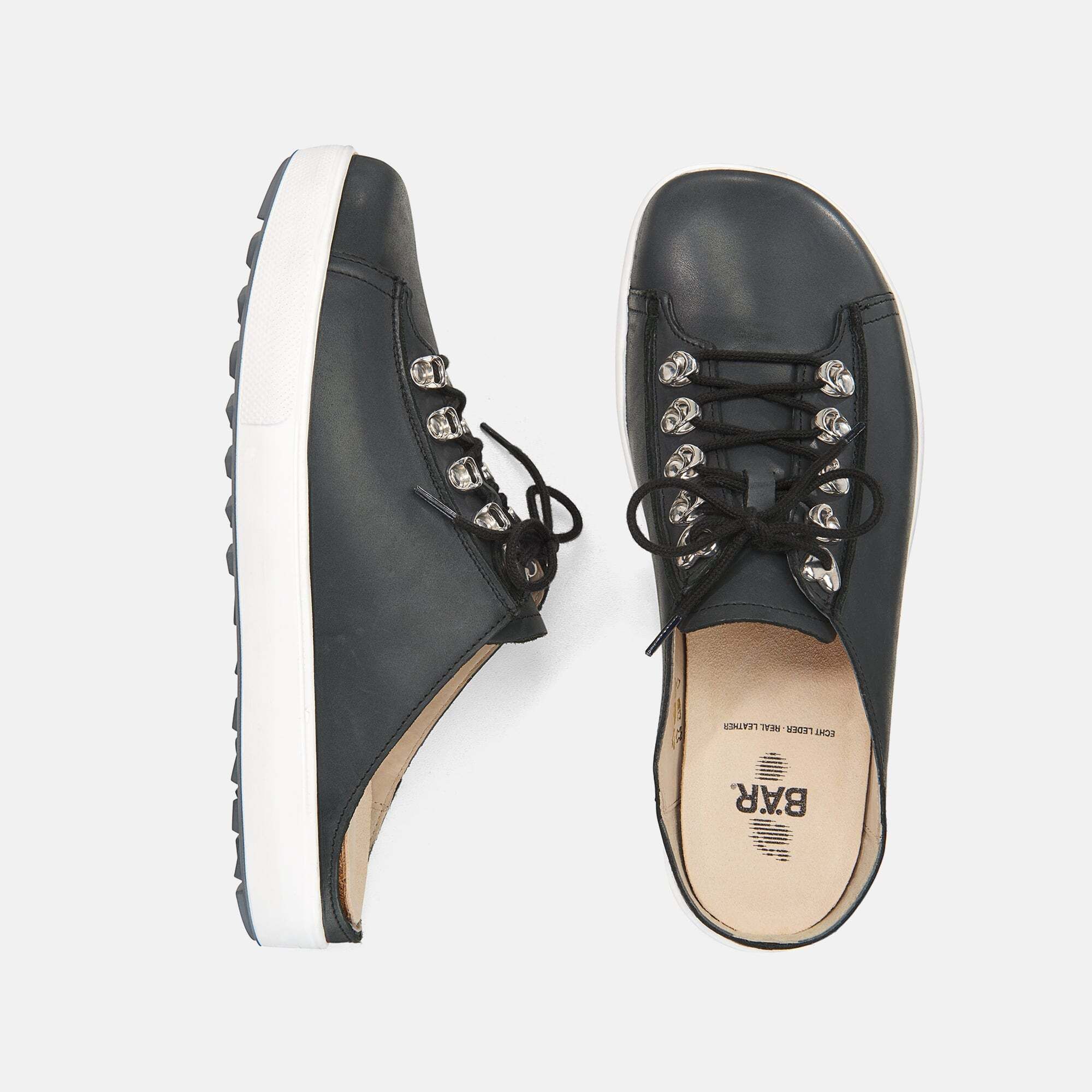 Schwarze Pantoletten mit Schnürsenkeln und silberfarbenen Ösen. Weiße Sohle. Draufsicht und Seitenansicht.