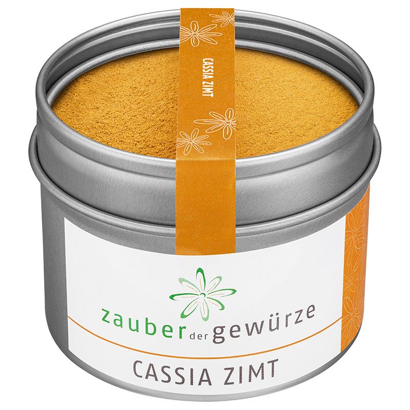 Metallbehälter mit gemahlenem Cassia-Zimt. Weißes Etikett mit Logo und Schriftzug. Orangefarbener Aufkleber mit Produktbezeichnung.