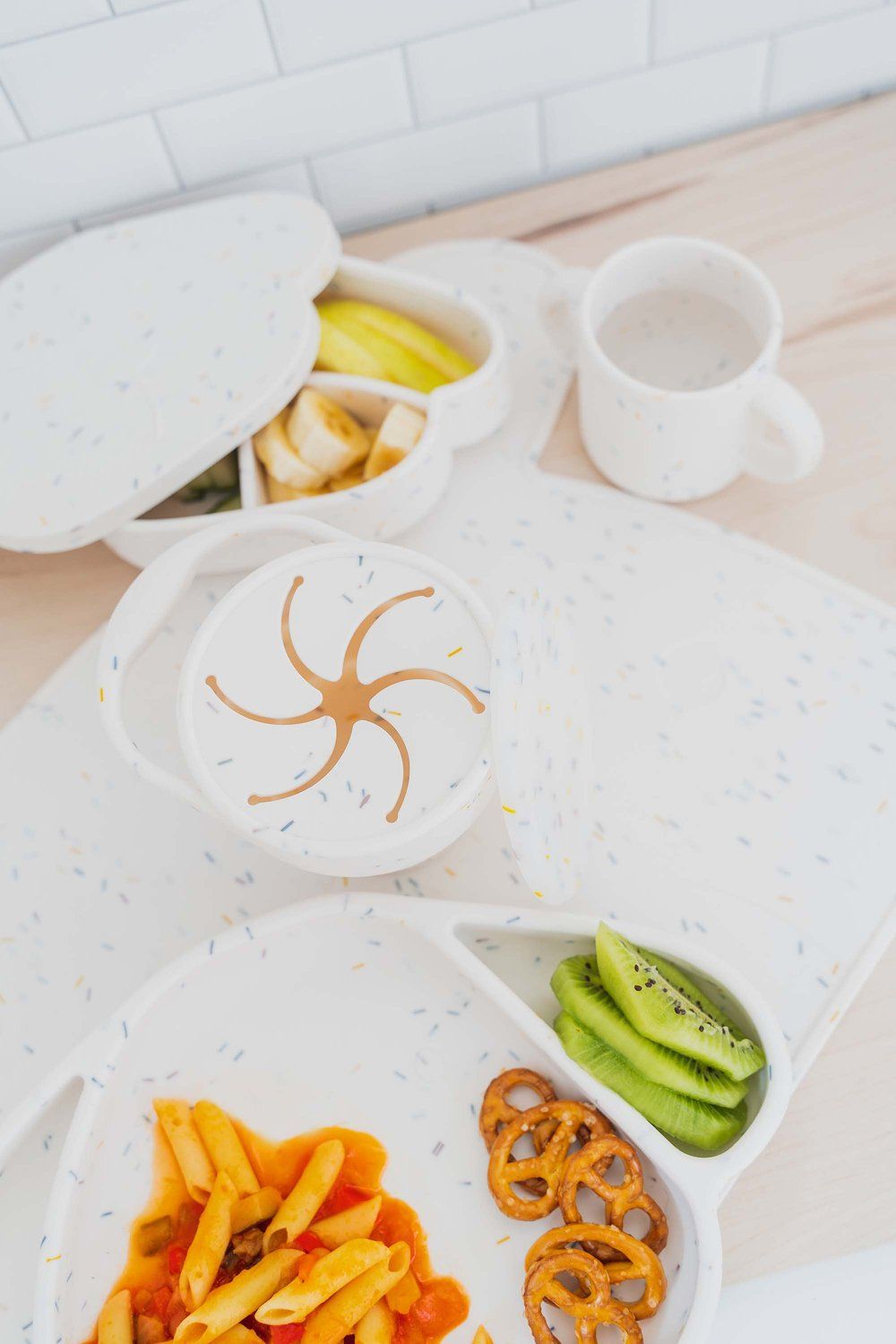 Essgeschirr-Set aus Silikon, weiß mit farbigen Punkten, mit Teller, Schüssel, Becher und Platzset.
