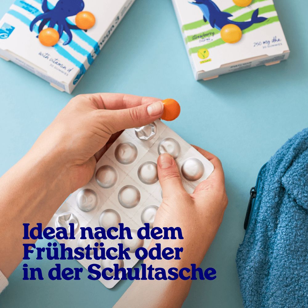 Hände halten eine Blisterpackung mit Gummibärchen. Aufschrift: Ideal nach dem Frühstück oder in der Schultasche.
