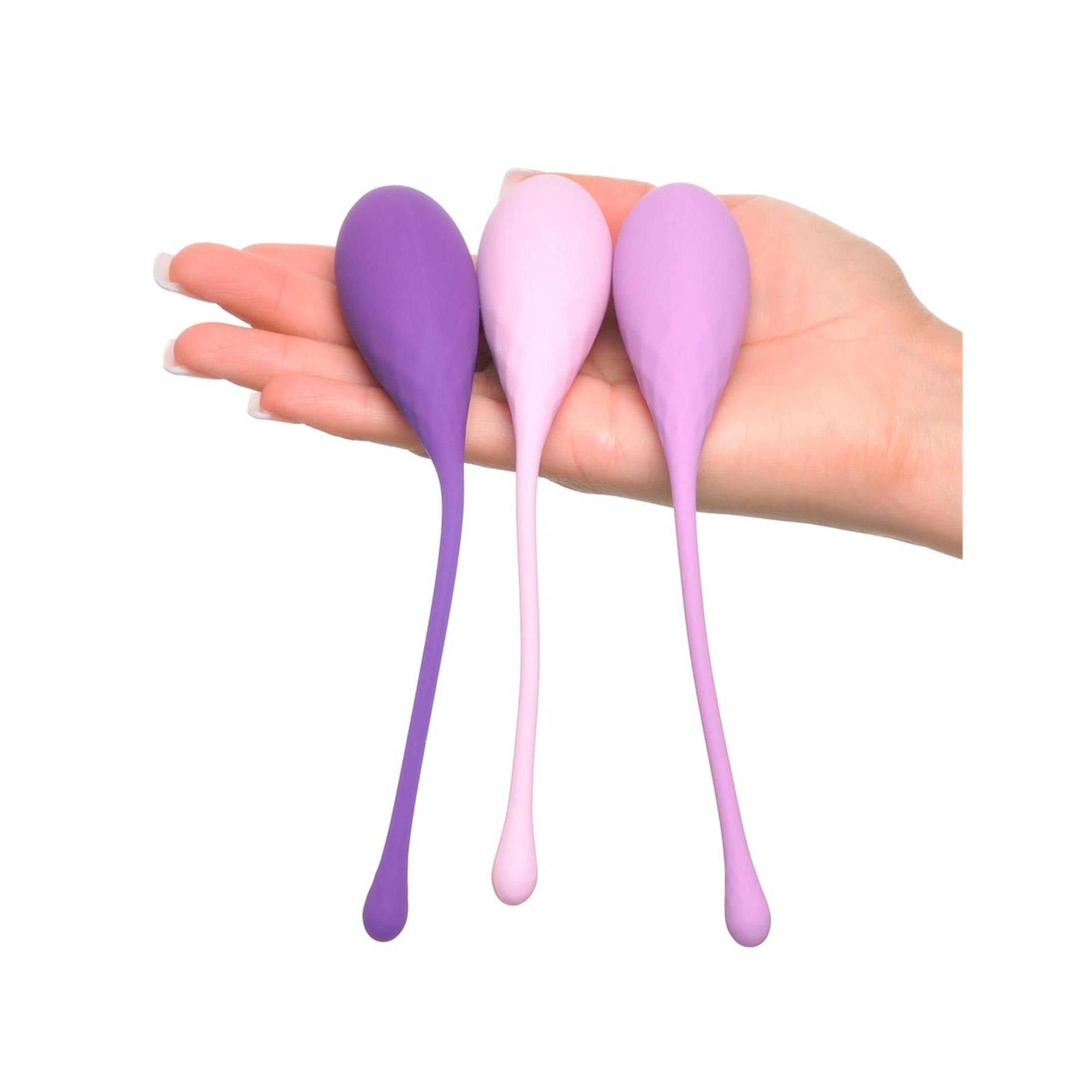 Drei Kegel-Trainingsgeräte in Lila-Tönen. Tropfenförmig mit geriffelter Oberfläche und langem Stiel.