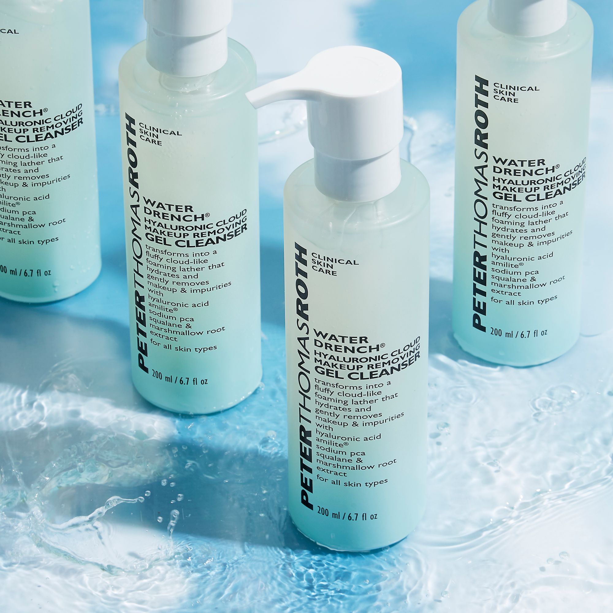 Mehrere Flaschen Hautpflegemittel mit Pumpe. Aufschrift: Water Drench Hyaluronic Cloud. Hellblaue Flaschen.