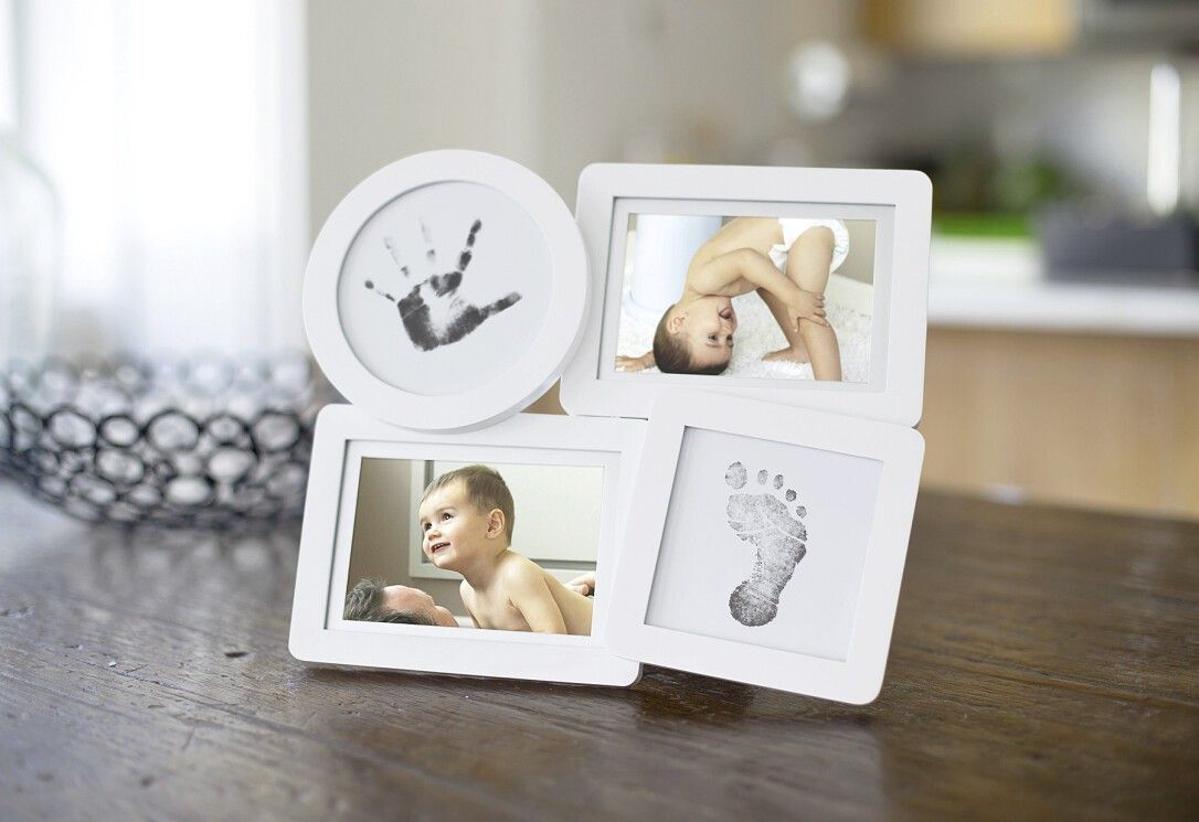Weißer Collage-Rahmen mit Hand- und Fußabdruck, sowie zwei Babyfotos. Auf Holztisch platziert. Runde und rechteckige Fächer.