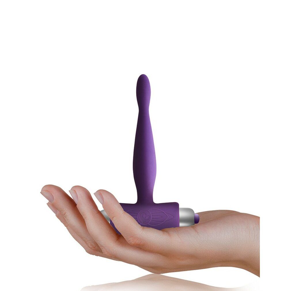 Lila Produkt in Hand gehalten. T-förmig mit abgerundeter Spitze und zylindrischem Ende.