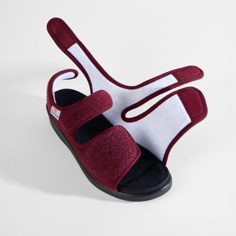 Rote Sandale mit Klettverschluss und atmungsaktivem Mesh-Obermaterial.
