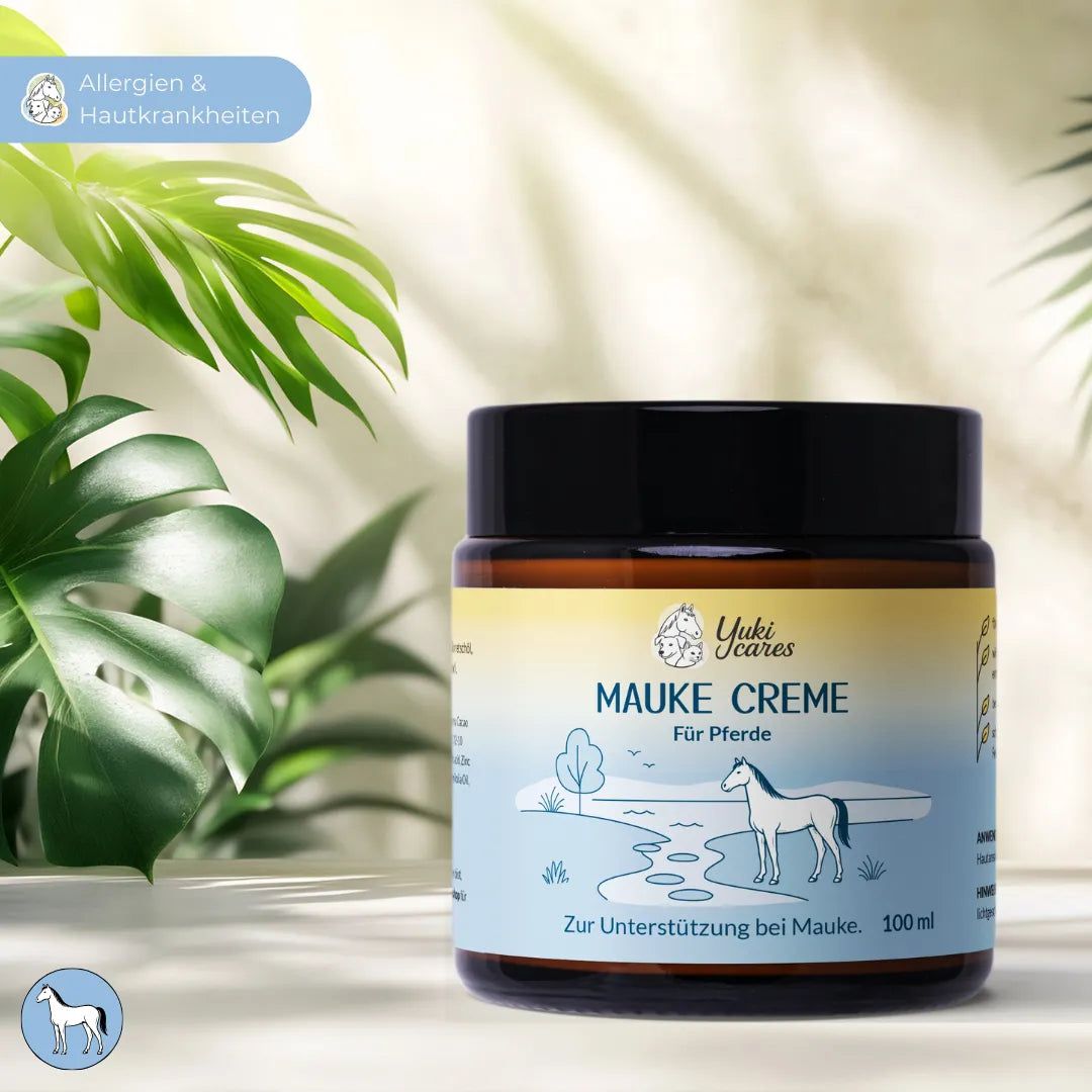 Braunes Glas mit schwarzem Deckel. Aufschrift: Mauke Creme für Pferde. Logo: Yuki cares. Hintergrund: Blätter.
