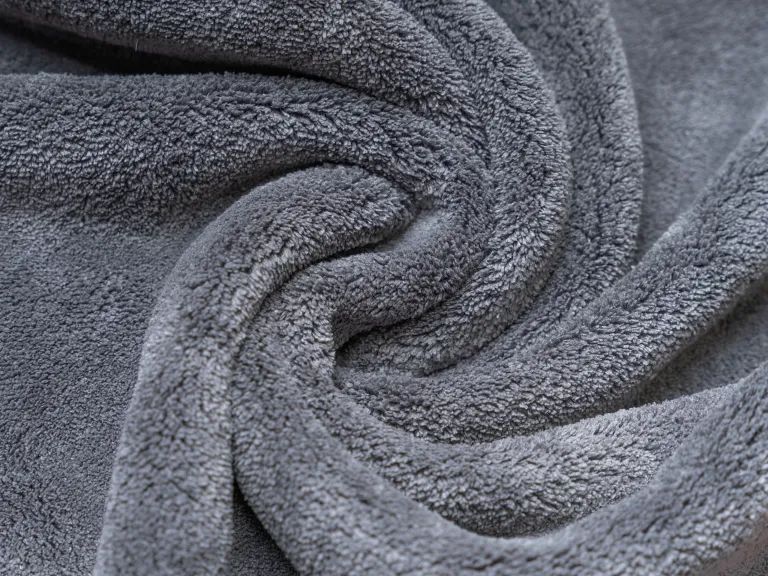 Graues, flauschiges Trockentuch. Nahaufnahme, Texturdetails sichtbar.
