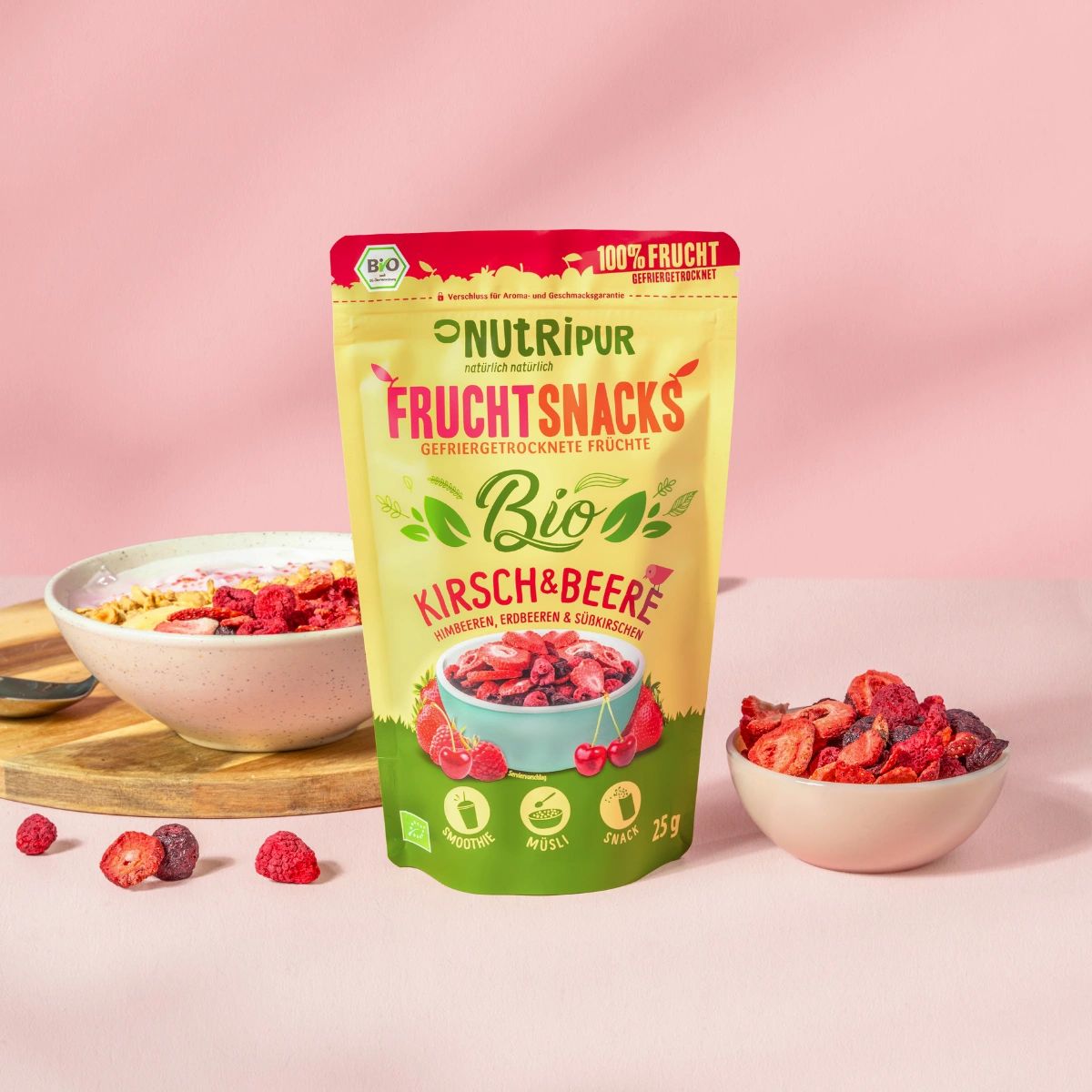 Beutel mit gefriergetrockneten Früchten, Kirschen & Beeren. Eine Schale mit Müsli und Früchten, eine Schale mit Früchten, Früchte verstreut.