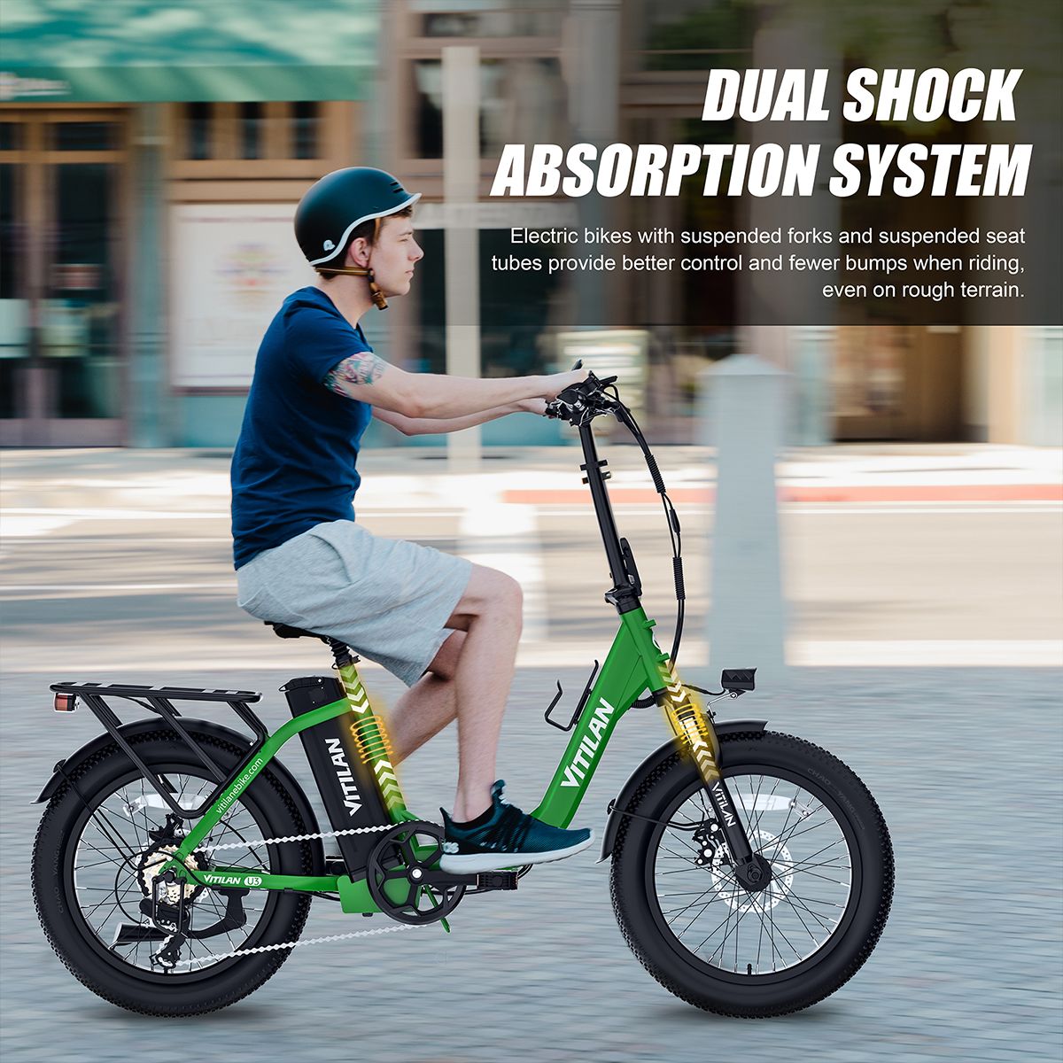 Grünes E-Bike in Bewegung. Mann fährt auf Straße. Duales Stoßdämpfersystem. VITILAN-Logo sichtbar.