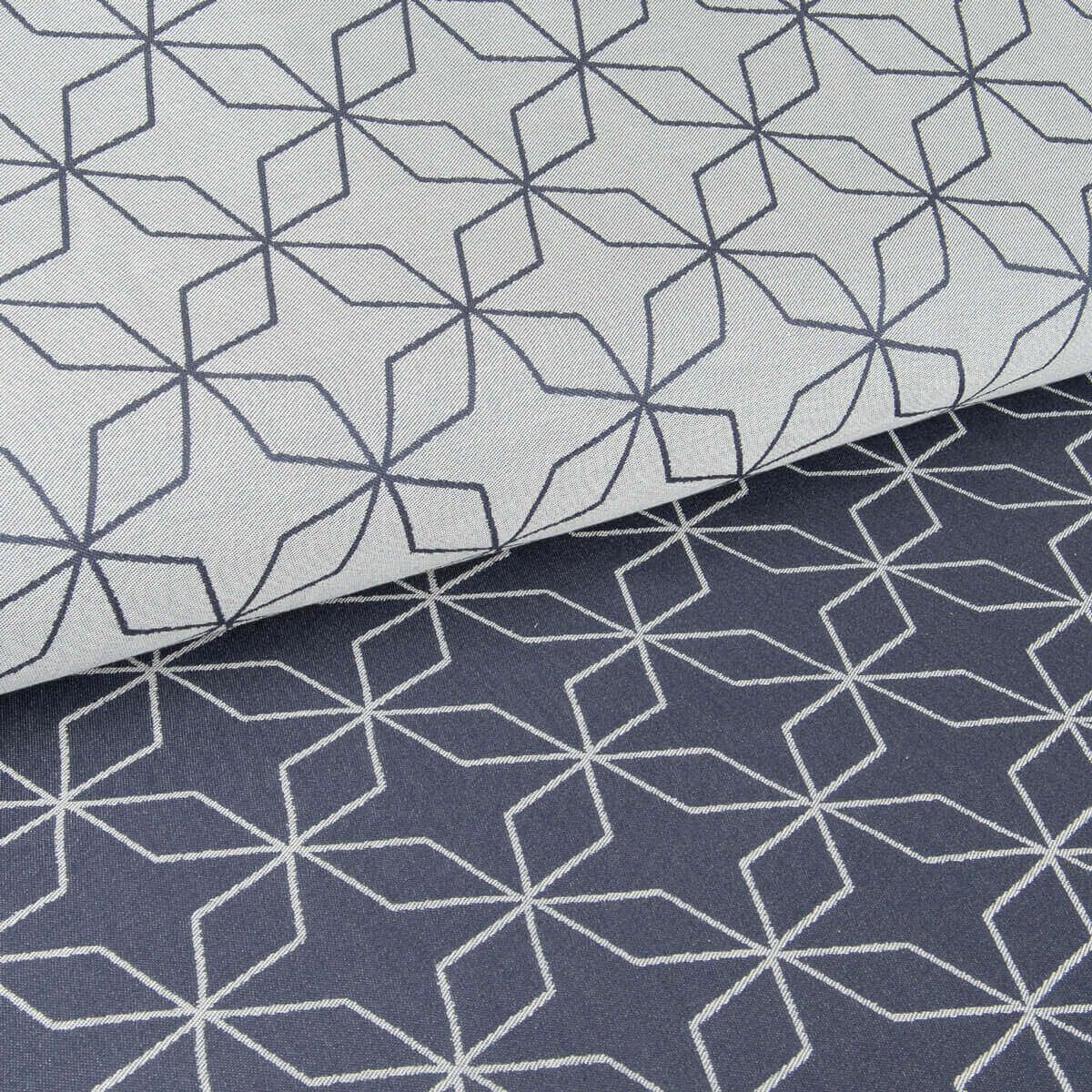 Stoffmuster, blau-weißes geometrisches Muster. Zwei Stofflagen, eine gefaltet. Helles Muster auf hellem Grund, dunkles Muster auf dunklem Grund.