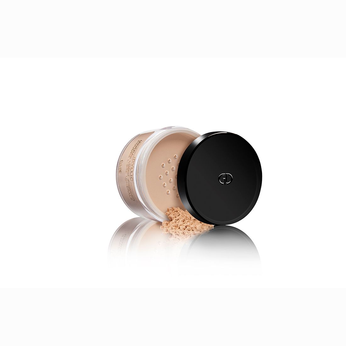 Ga-De Idyllic Mineral Loose Powder. Dose mit schwarzem Deckel. Puder auf weißem Untergrund verstreut.
