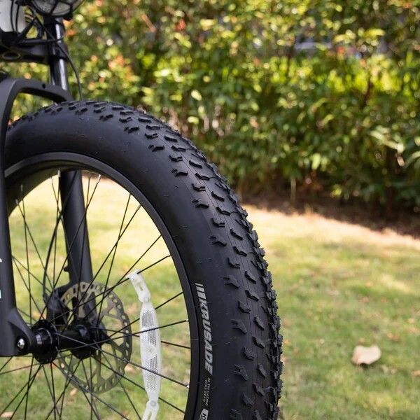 Schwarzer Fahrradreifen mit grobem Profil. Marke: KRUSADE. Teil des Vorderrads.