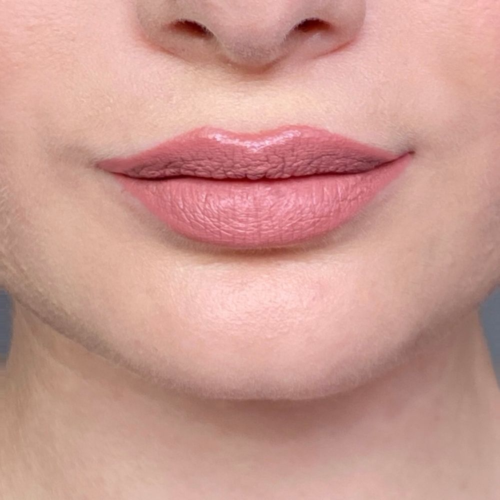 Nahaufnahme von Lippen mit rosafarbenem Lippenstift. Hautton, glänzendes Finish.