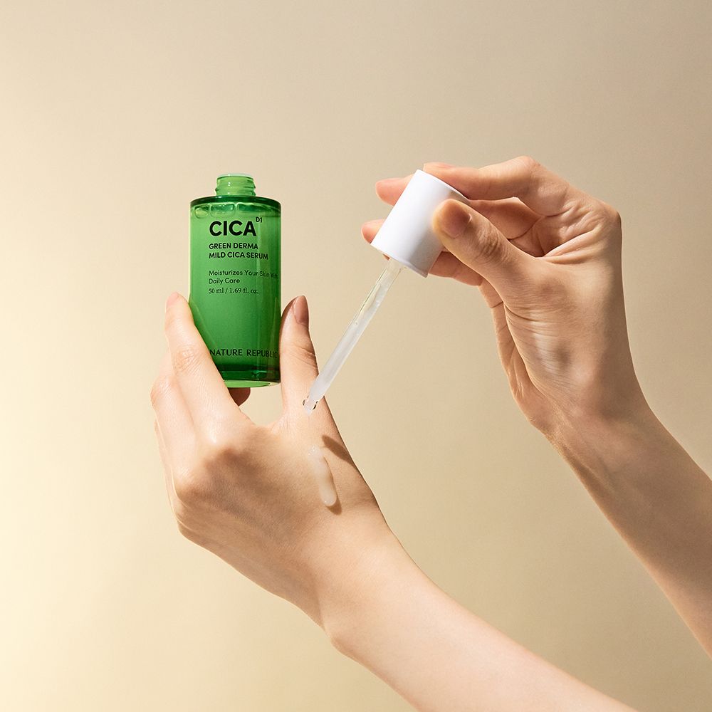 Hände halten eine grüne Serumflasche und eine Pipette. Serum wird auf die Haut aufgetragen. Aufschrift: CICA, Green Derma Mild Cica Serum.