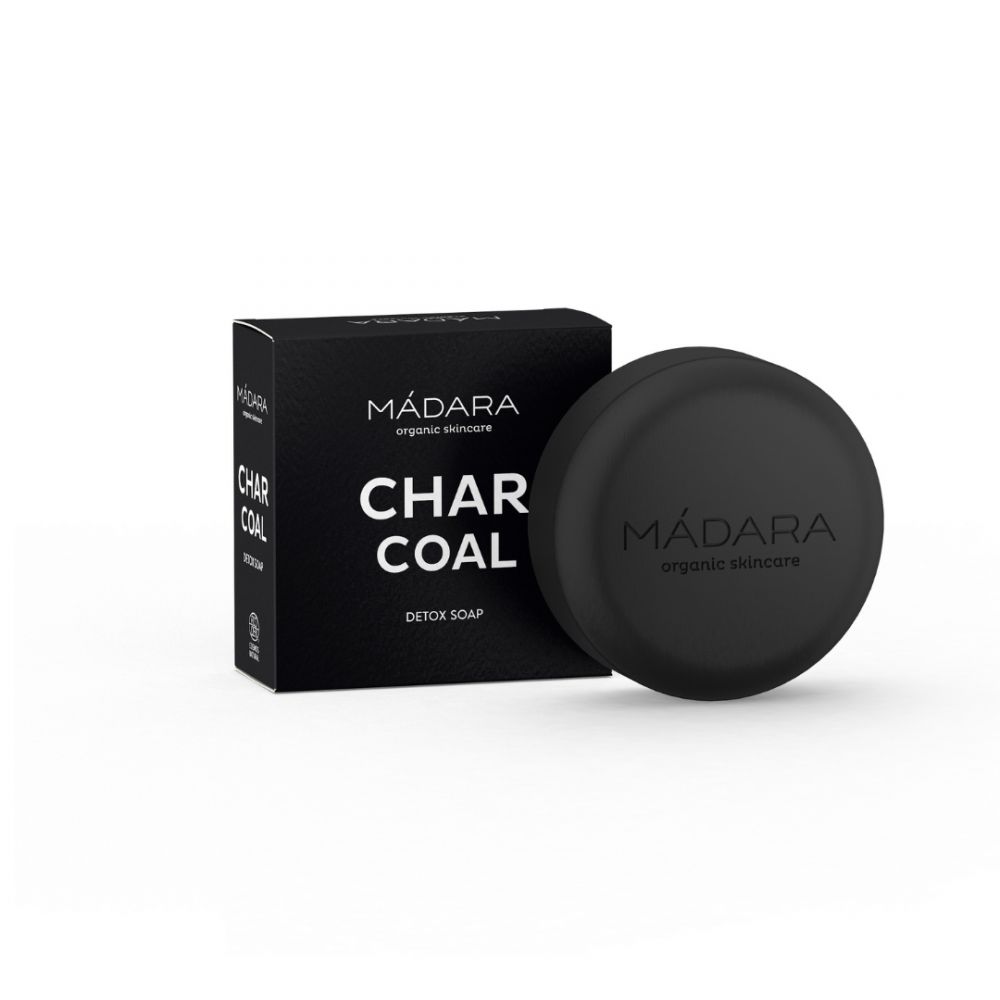 Schwarze Seife und Schachtel. Auf der Schachtel steht "MÁDARA CHAR COAL DETOX SOAP". Die Seife ist rund und hat das Logo "MÁDARA organic skincare".