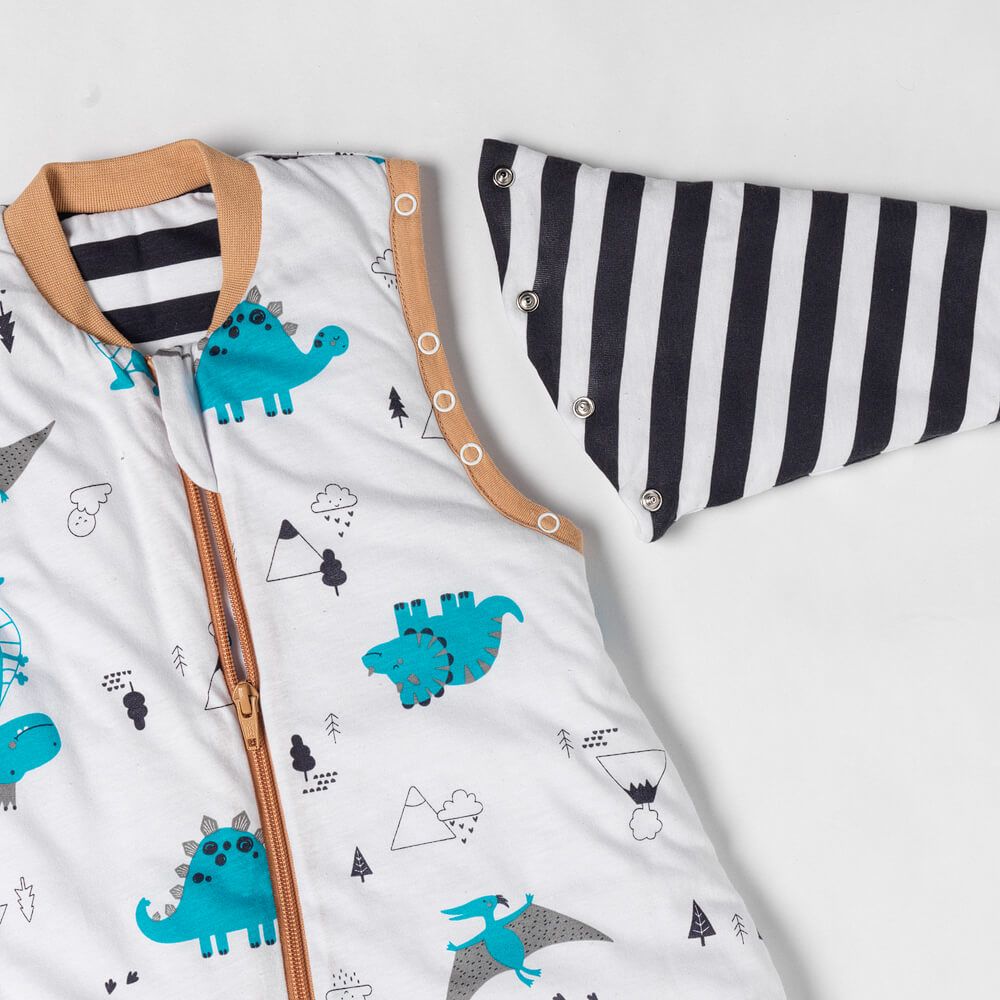 Detailansicht des Schlafsacks mit Dinosaurier-Muster, Reißverschluss, abnehmbarem Ärmel mit Streifen.
