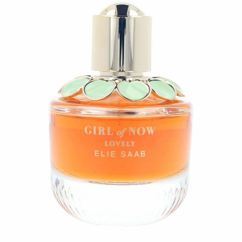 Parfümflasche mit goldfarbenem Deckel, orangefarbener Flüssigkeit und grünen Blütenblättern. Produktname und Marke sind sichtbar.