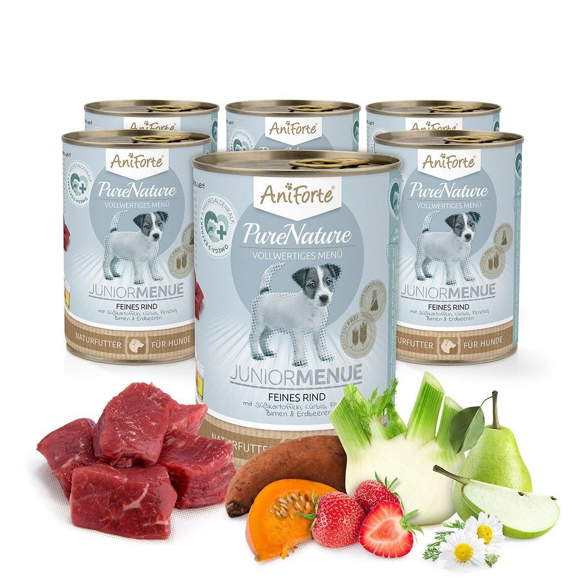 Mehrere Dosen Aniforte Nassfutter JuniorMenue Feines Rind. Aufschrift: PureNature, JuniorMenue, Feines Rind. Daneben Fleisch, Gemüse und Obst.