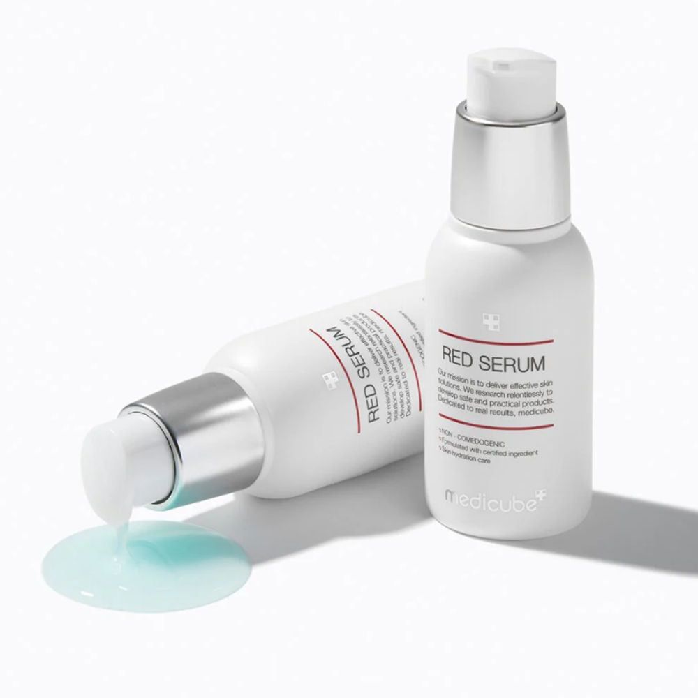 Zwei weiße Flaschen mit silbernen Deckeln. Eine Flasche liegt, die andere steht. Aufschrift: RED SERUM.