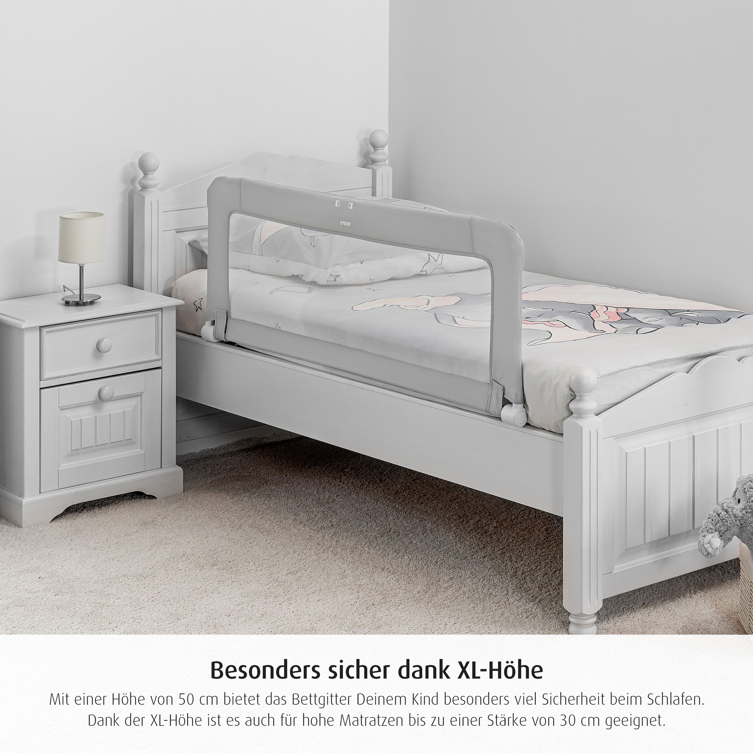 Bettgitter am Bett montiert. Grau mit weißem Netz. Marke reer. Text: Besonders sicher dank XL-Höhe.