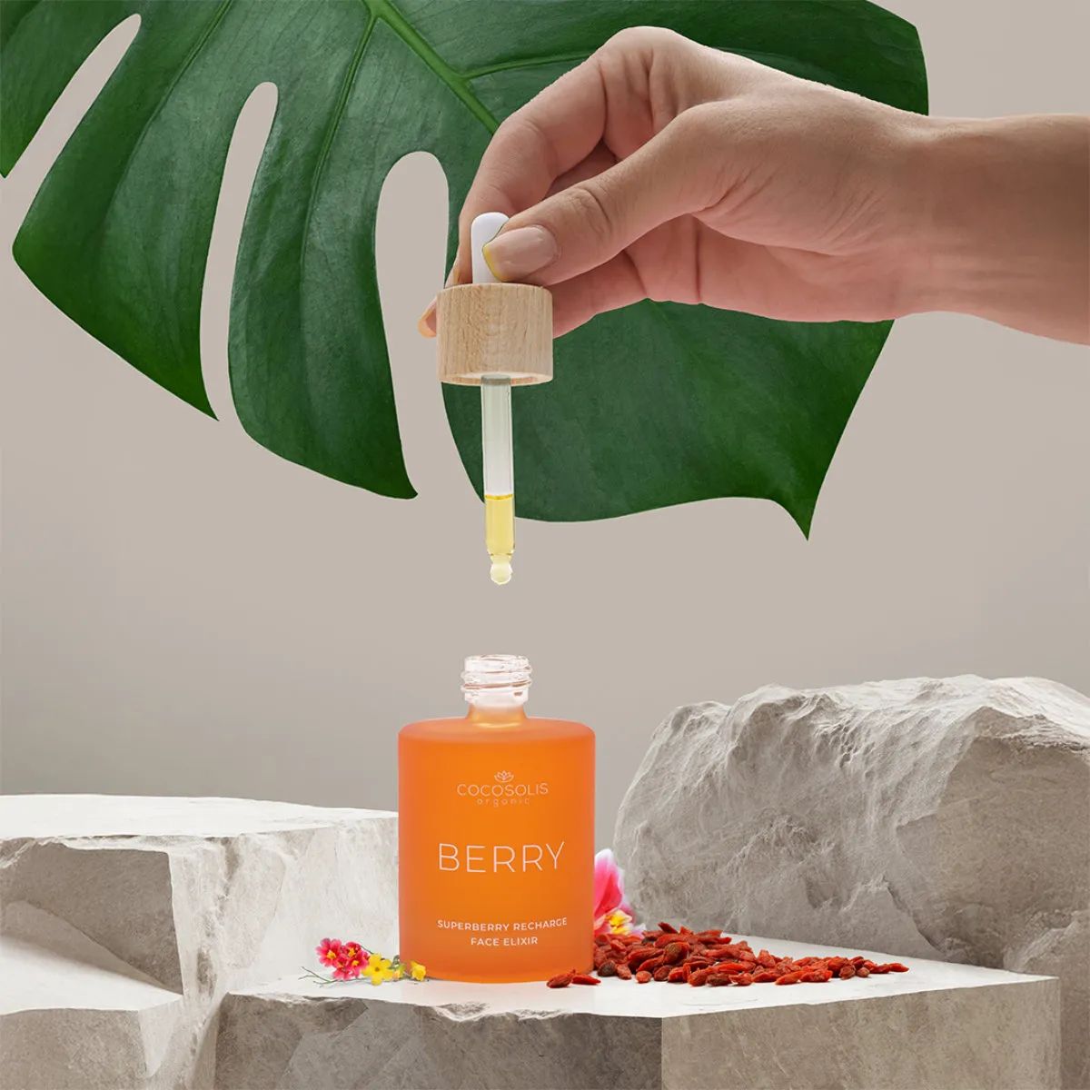 Orangefarbene Glasflasche mit Pipette, gefüllt mit goldenem Elixier. Beschriftung: Cocosolis, Berry, Superberry Recharge Face Elixir.