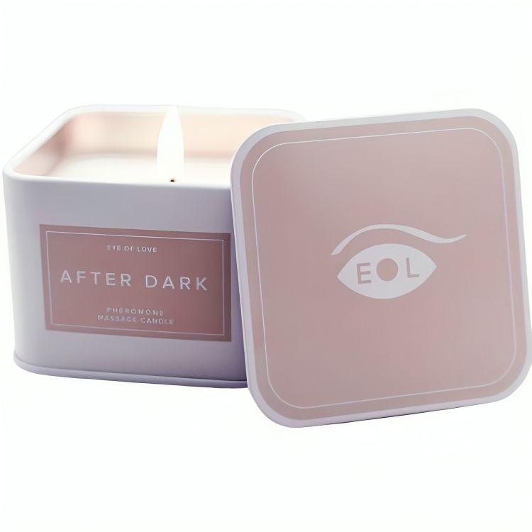 Weiße Massagekerze in rechteckiger weißer Dose mit rosa Etikett. "AFTER DARK" und "Pheromone Massage Candle" sind auf dem Etikett aufgedruckt.