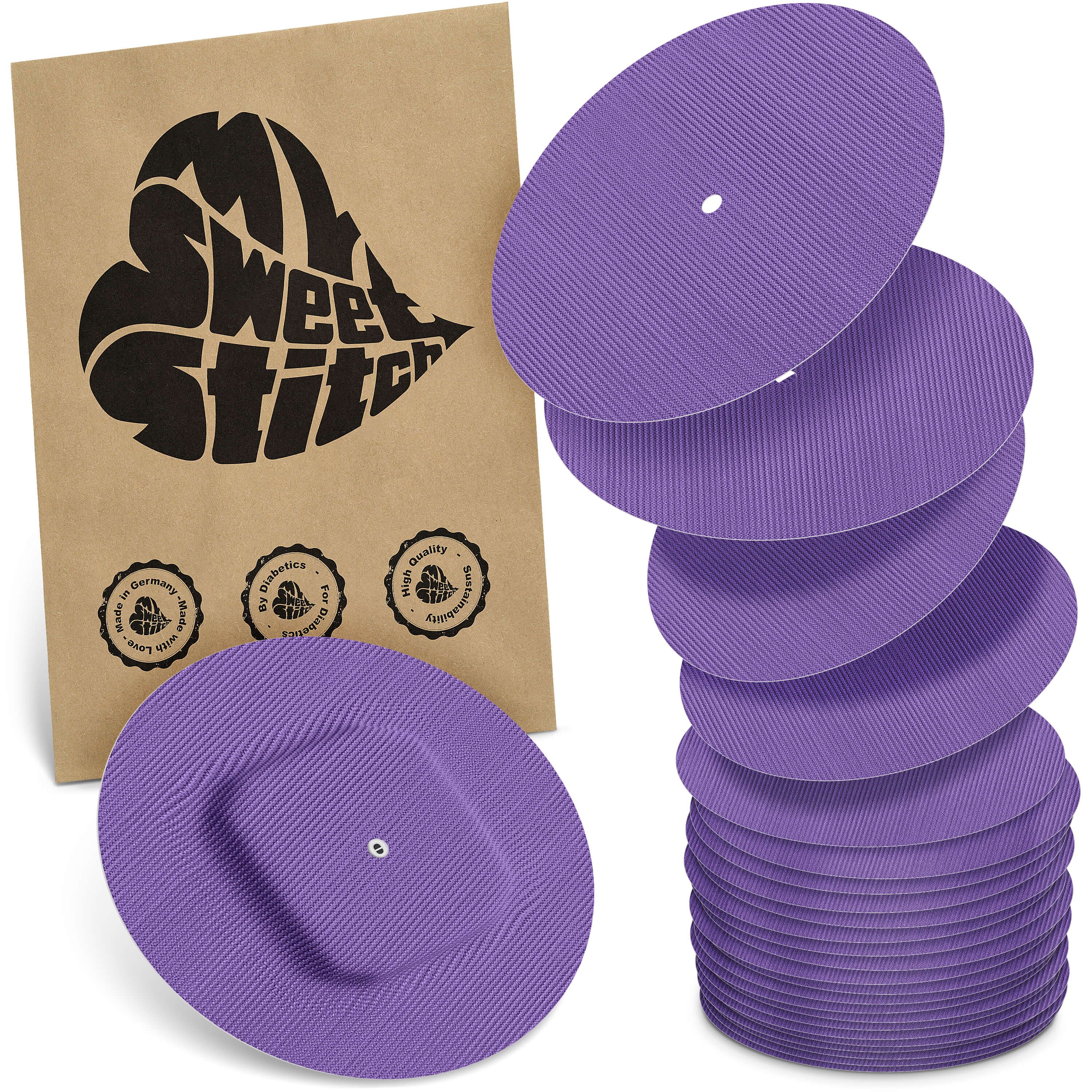 Verpackung mit Logo und lilafarbenen, runden Pflastern. Einige Pflaster sind gestapelt, andere liegen daneben. Auf der Verpackung steht "My Sweet Stitch".