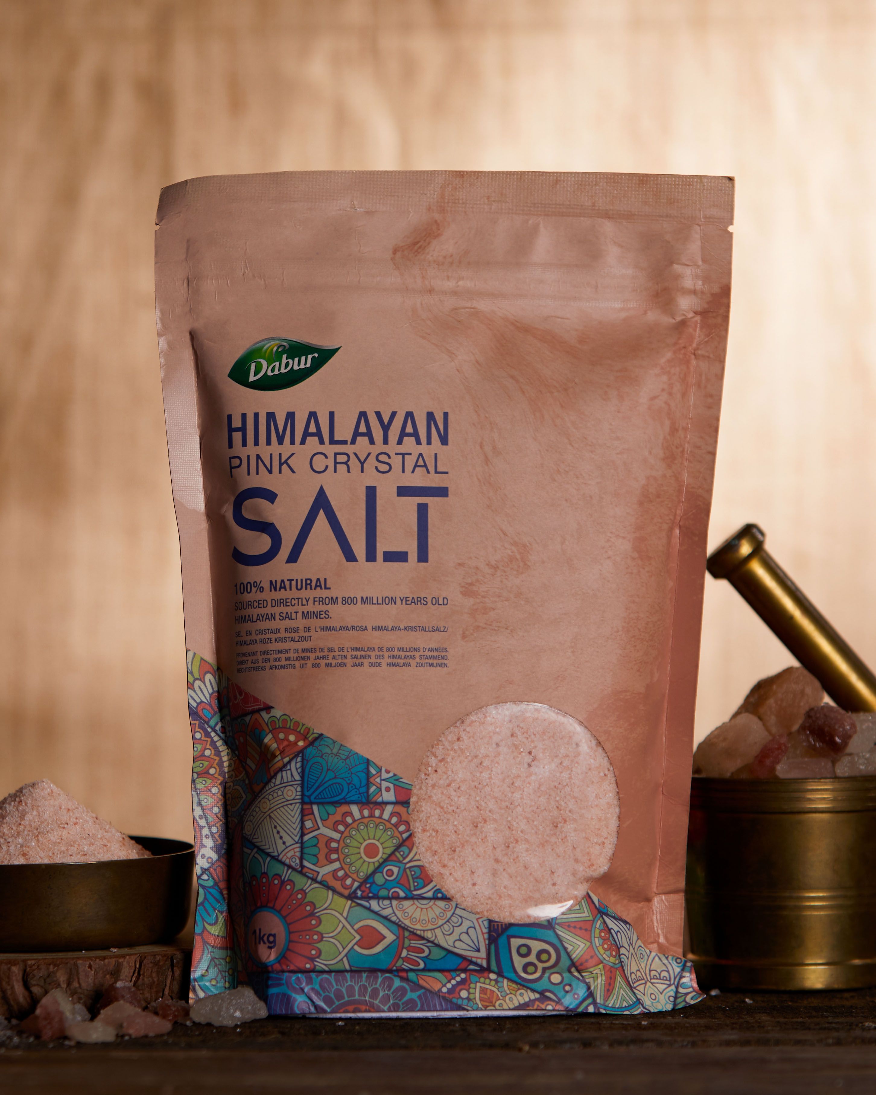 Beutel Dabur Himalayan Pink Crystal Salt. Rosa Salz in Schalen. Mörser und Stößel. Aufschrift: 100% natürlich.