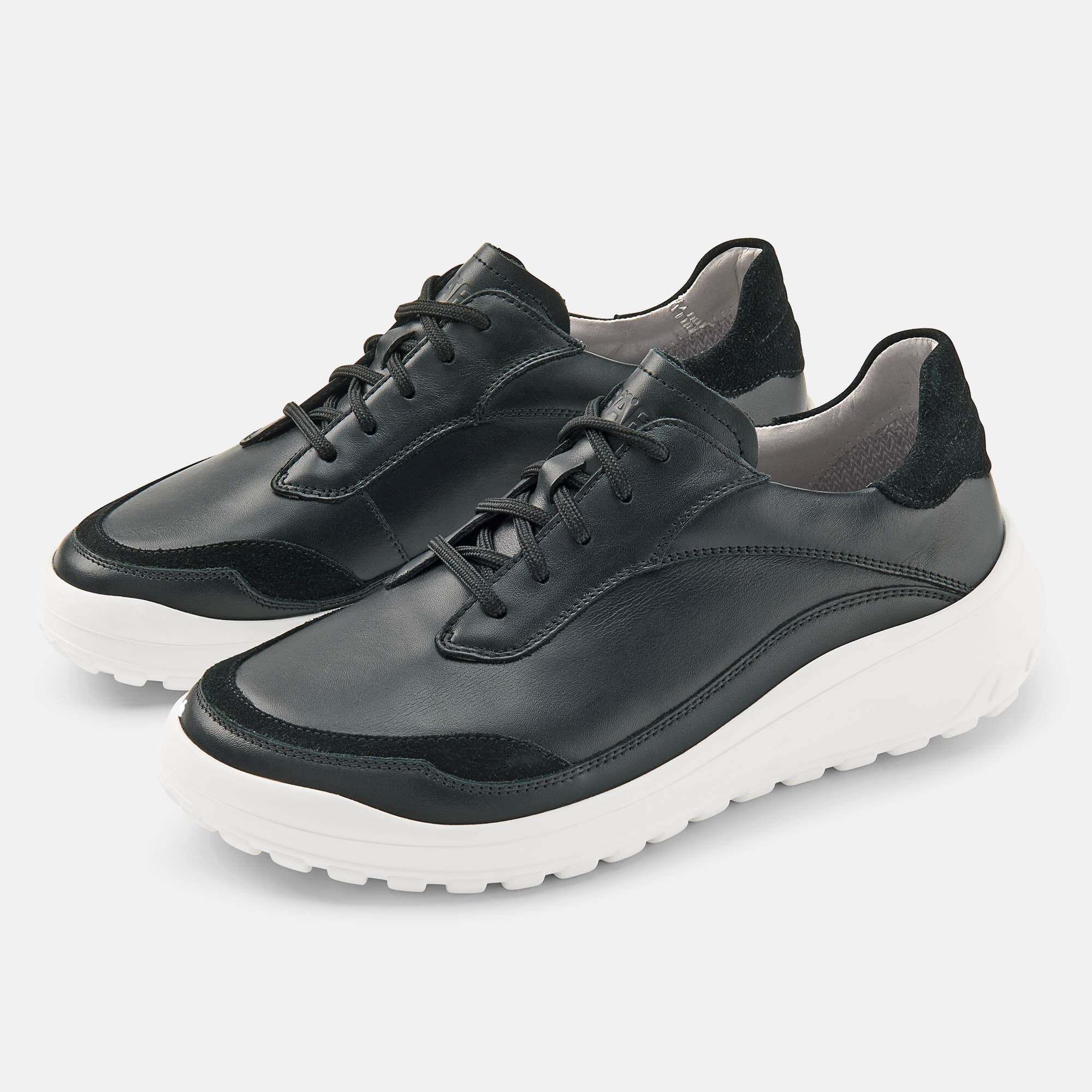 Schwarze Damen-Schnürschuhe aus Leder mit weißer Sohle und Wildleder-Akzenten.