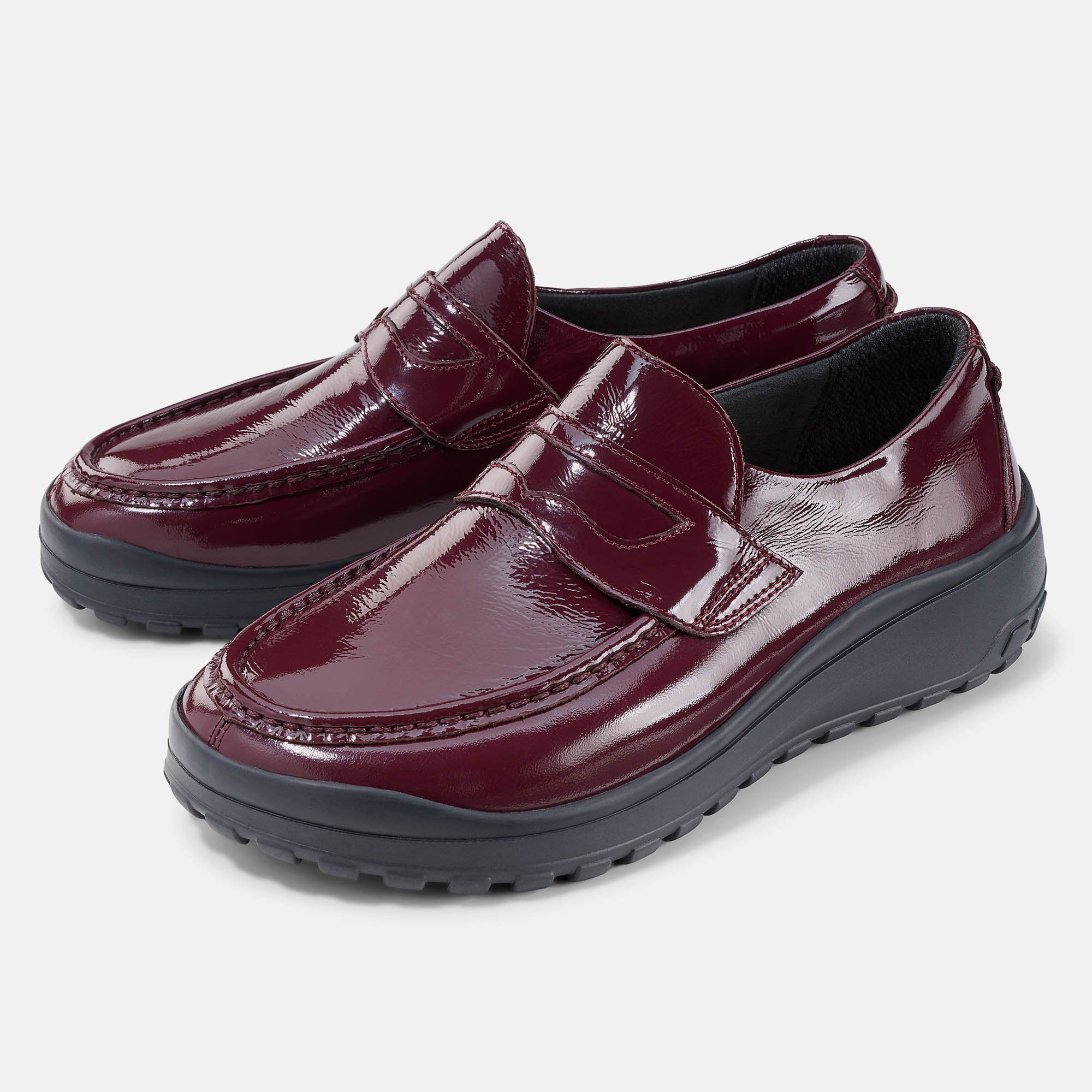 Zwei bordeauxfarbene Damen-Slipper mit breiter Passform. Glänzendes Obermaterial, schwarze Sohle.