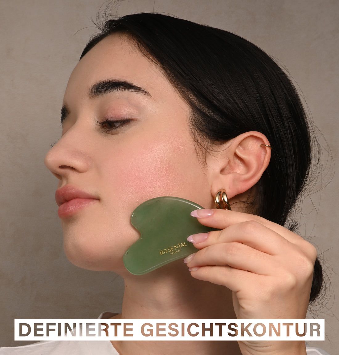 Frau verwendet grünen Gua Sha am Gesicht. Text: DEFINIERTE GESICHTSKONTUR. Rosental-Logo sichtbar.