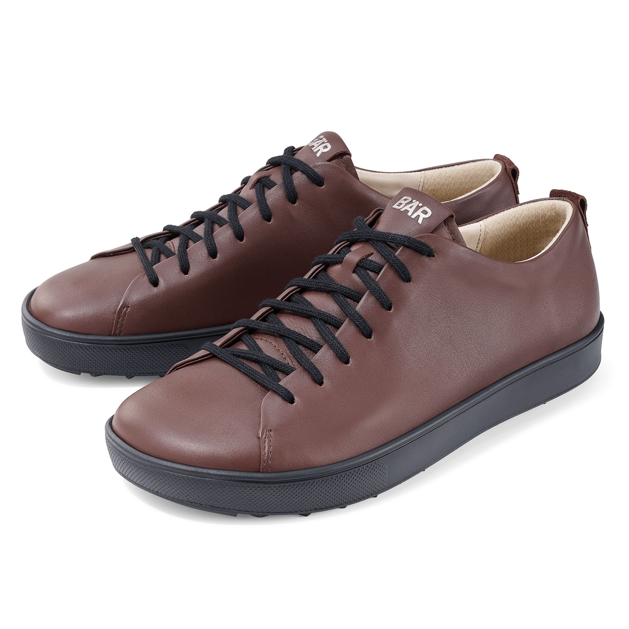 Zwei braune BÄR Schuhe Dale Unisex-Schnürer mit schwarzer Sohle und Schnürsenkeln. Das BÄR-Logo ist auf der Zunge zu sehen.