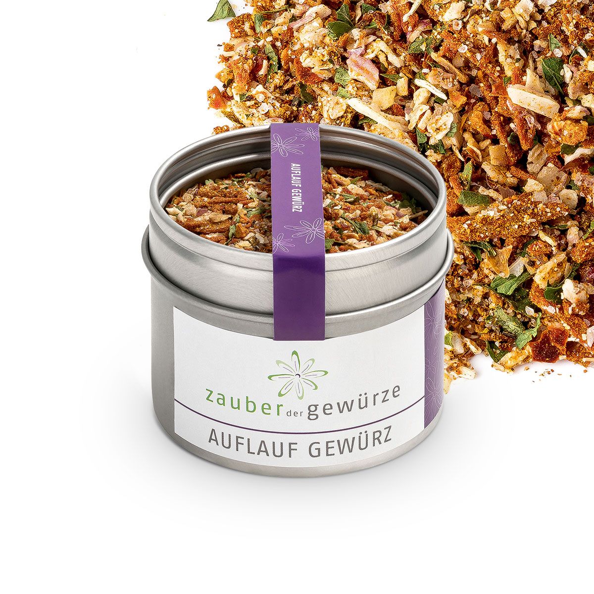 Offene Metallbox mit Gewürzmischung. Aufkleber mit "Zauber der Gewürze Auflauf Gewürz". Lila Band. Gewürze daneben.