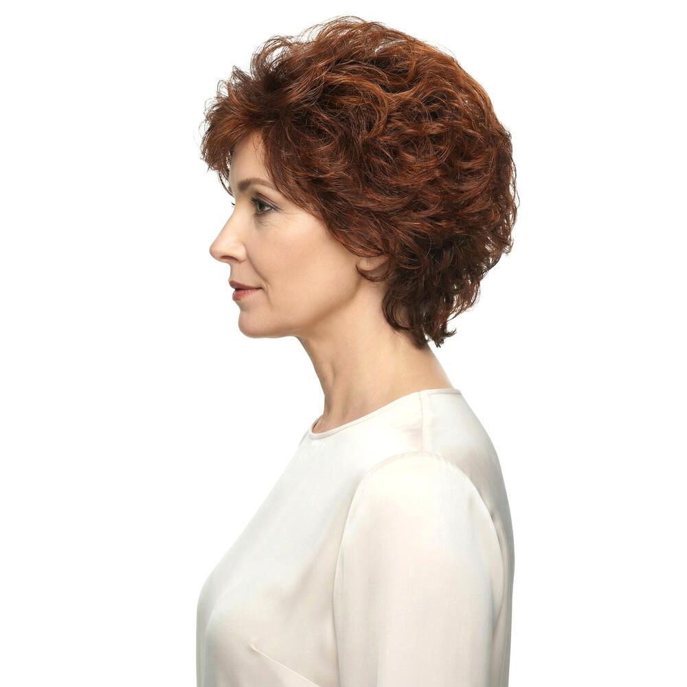 Profil einer Frau mit roter Perücke MONACO. Kurze, lockige Haare. Helle Haut, weißes Oberteil. Blick nach links.