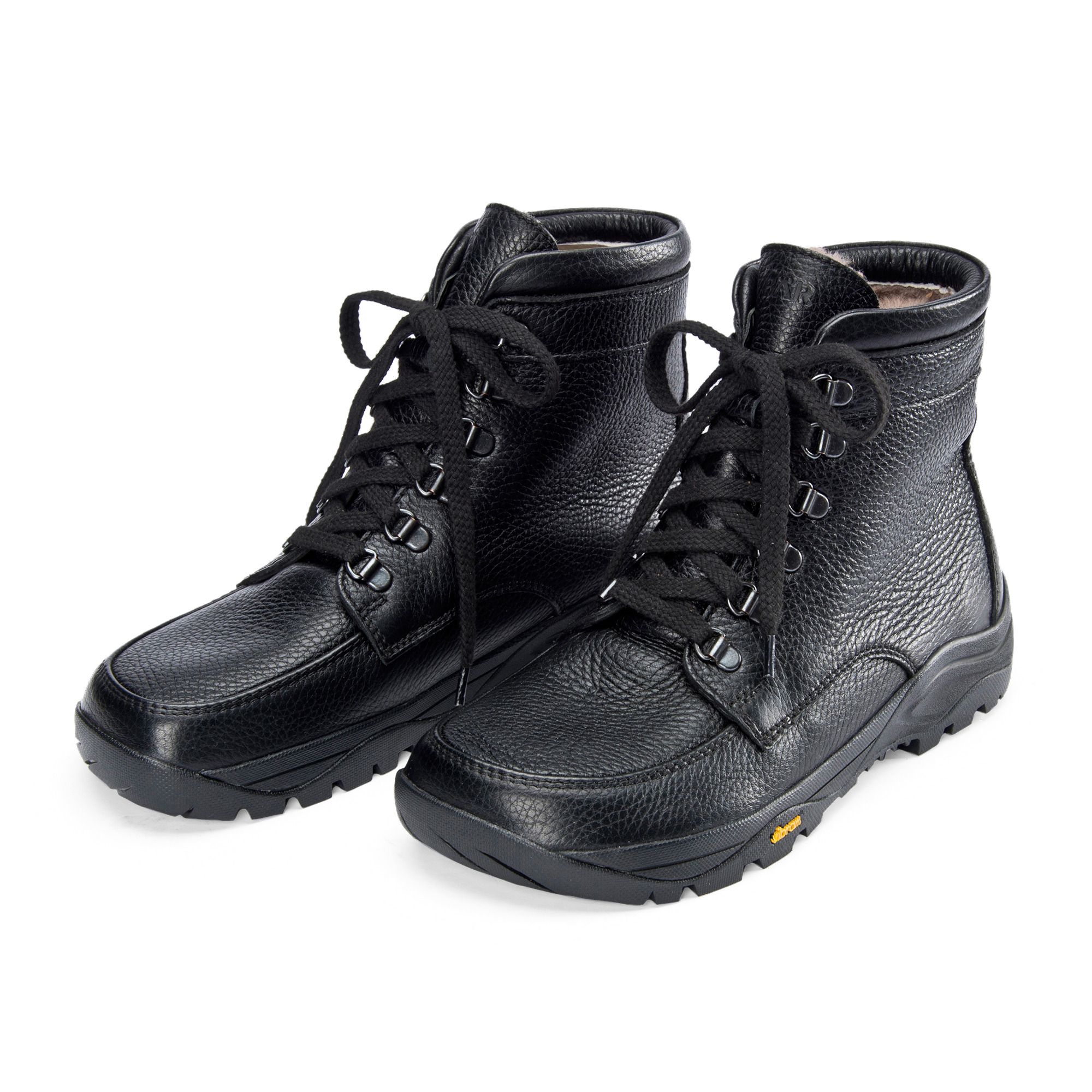 Schwarze Lederstiefel mit Schnürsenkeln. Breite Passform. Lammfellfutter sichtbar. Vibram-Sohle. Zwei Stiefel nebeneinander.