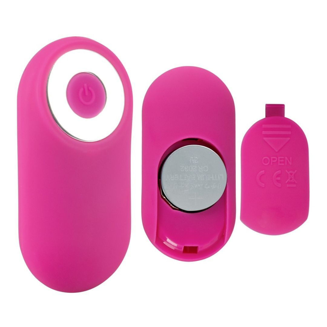 Pinkfarbene Fernbedienung und Batteriefach. Die Fernbedienung hat einen Knopf. Das Batteriefach ist geöffnet.
