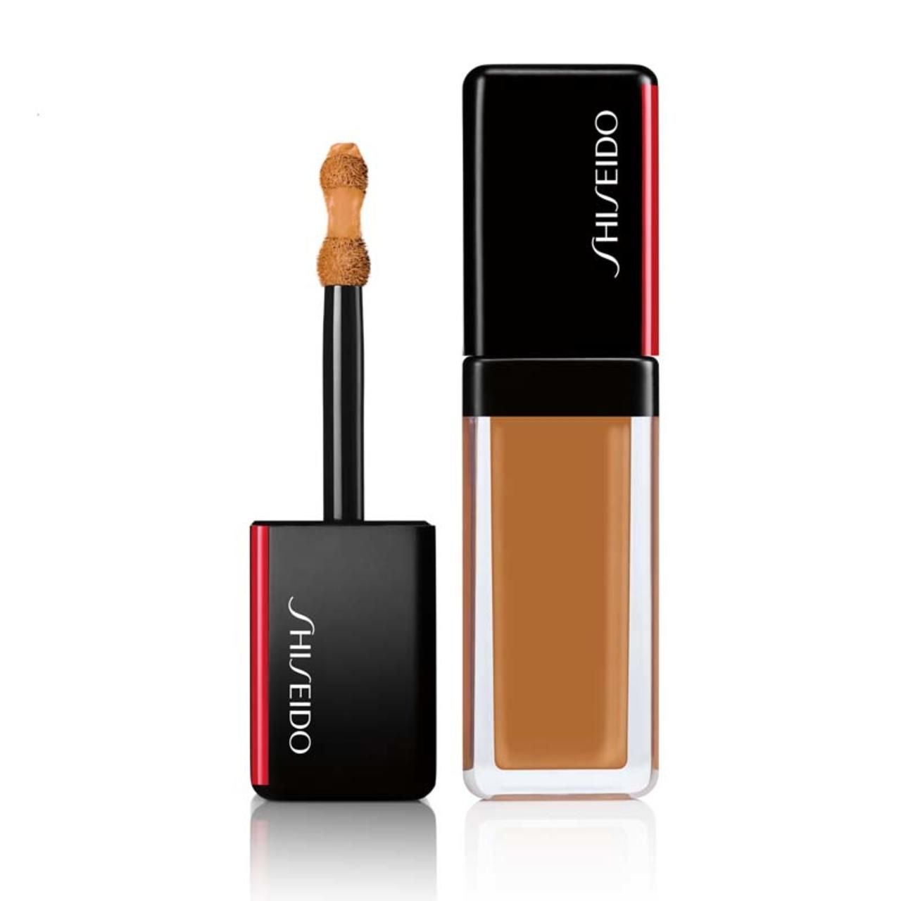 Behälter mit Concealer, geöffnet. Schwarzer Deckel mit rotem Akzent und Shiseido-Logo. Applikator sichtbar.