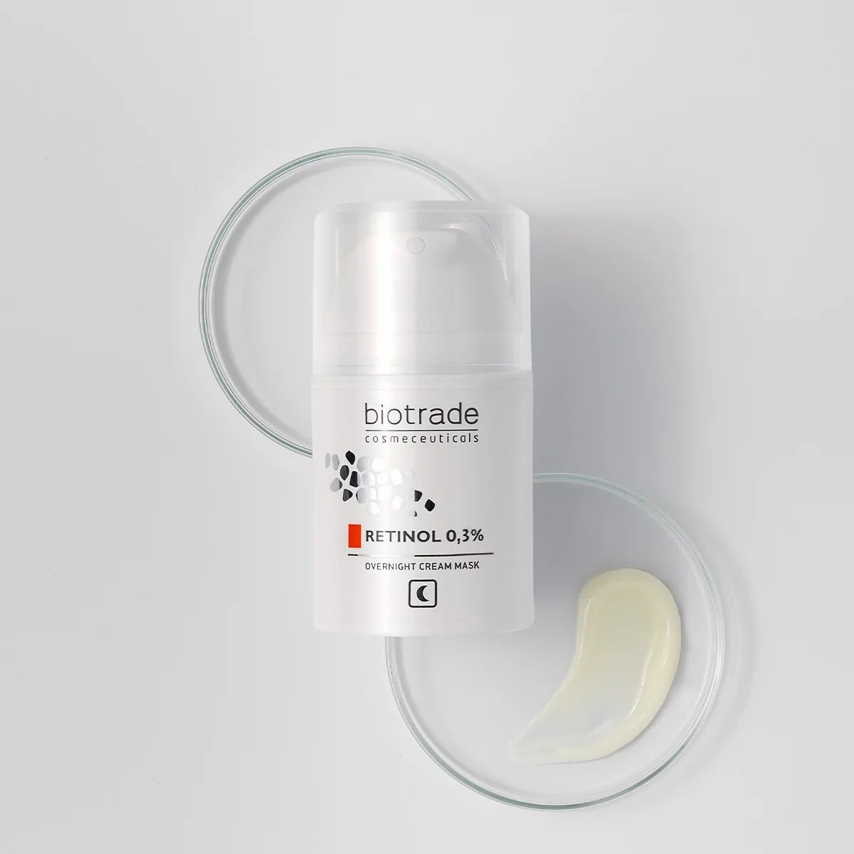 Weiße Flasche mit Aufschrift Biotrade, Retinol 0,3% und Nachtcreme-Gesichtsmaske. Auf Glasplatten mit Creme.