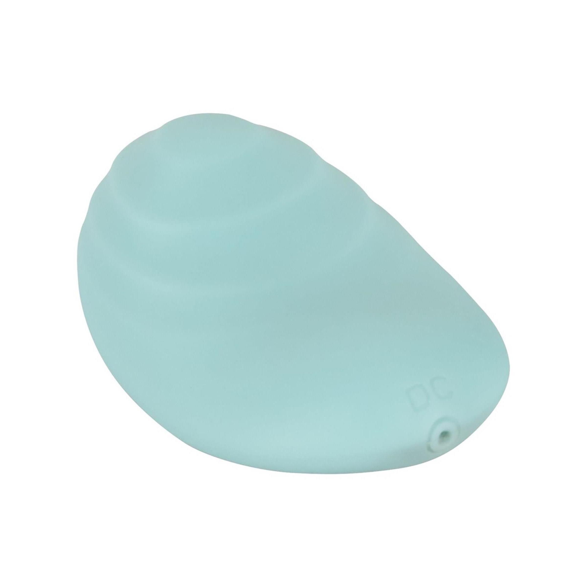 Hellblaues, ovales Vibrationsgerät. Geriffelte Oberfläche. DC-Anschluss. Form erinnert an eine Muschel.