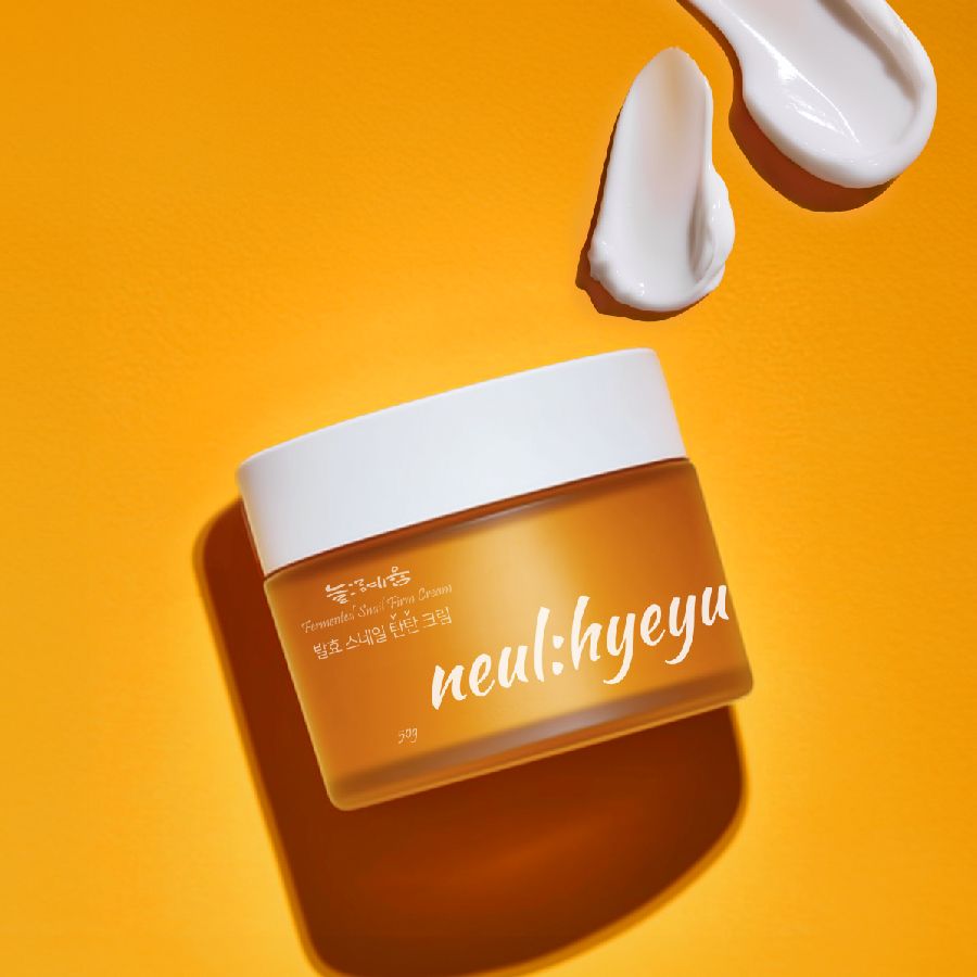 Orangefarbener Tiegel mit weißem Deckel. Aufschrift: neul:hyeyum. Zwei Kleckse Creme und ein Löffel.