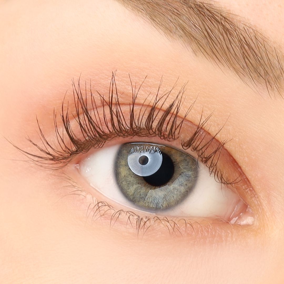 Nahaufnahme eines Auges mit braunem Mascara auf den Wimpern.