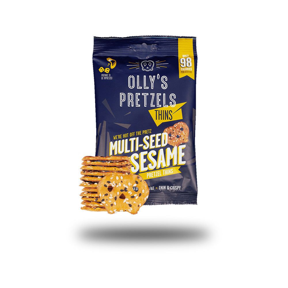 Verpackung mit Olly's Pretzel Thins. Aufschrift: Multi-Seed Sesame. Daneben ein Stapel und ein einzelner Pretzel Thin. Gelbe und blaue Farben.