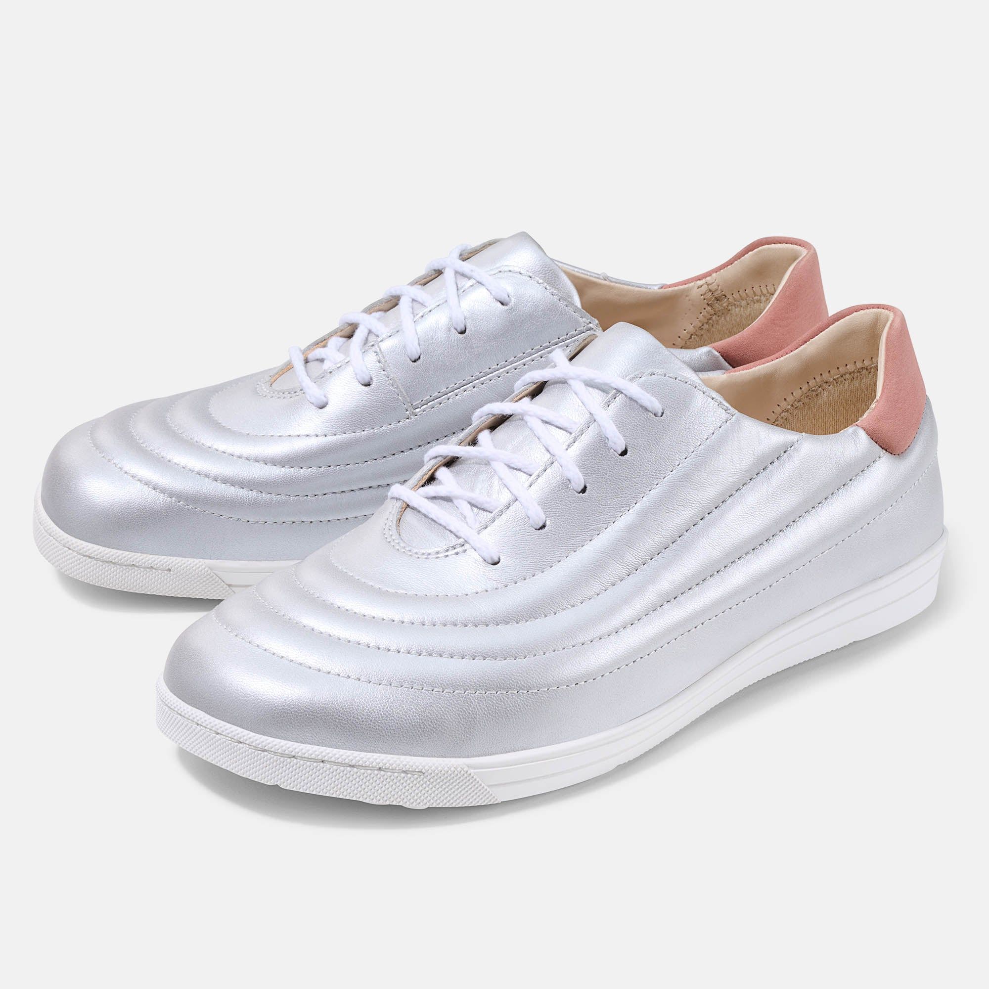 Silberfarbene Damenschnürschuhe mit weißer Sohle und Schnürsenkeln. Rosa Fersenkappe. Breite Passform.