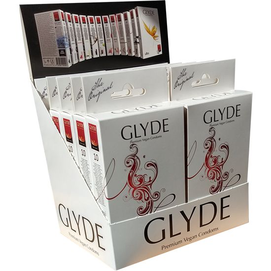 Display met condoomverpakkingen. Witte dozen met rood design en de tekst GLYDE. Opschrift: Premium Vegan Condoms.