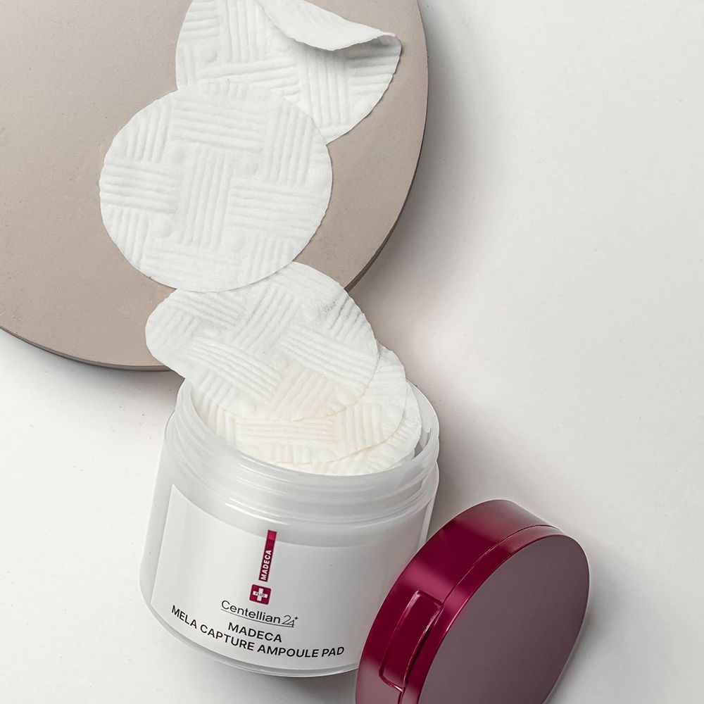 Geöffnete Dose mit Pads. Pads liegen auf einem Tablett. Aufschrift: Madeca Mela Capture Ampoule Pad. Marke: Centellian 24.