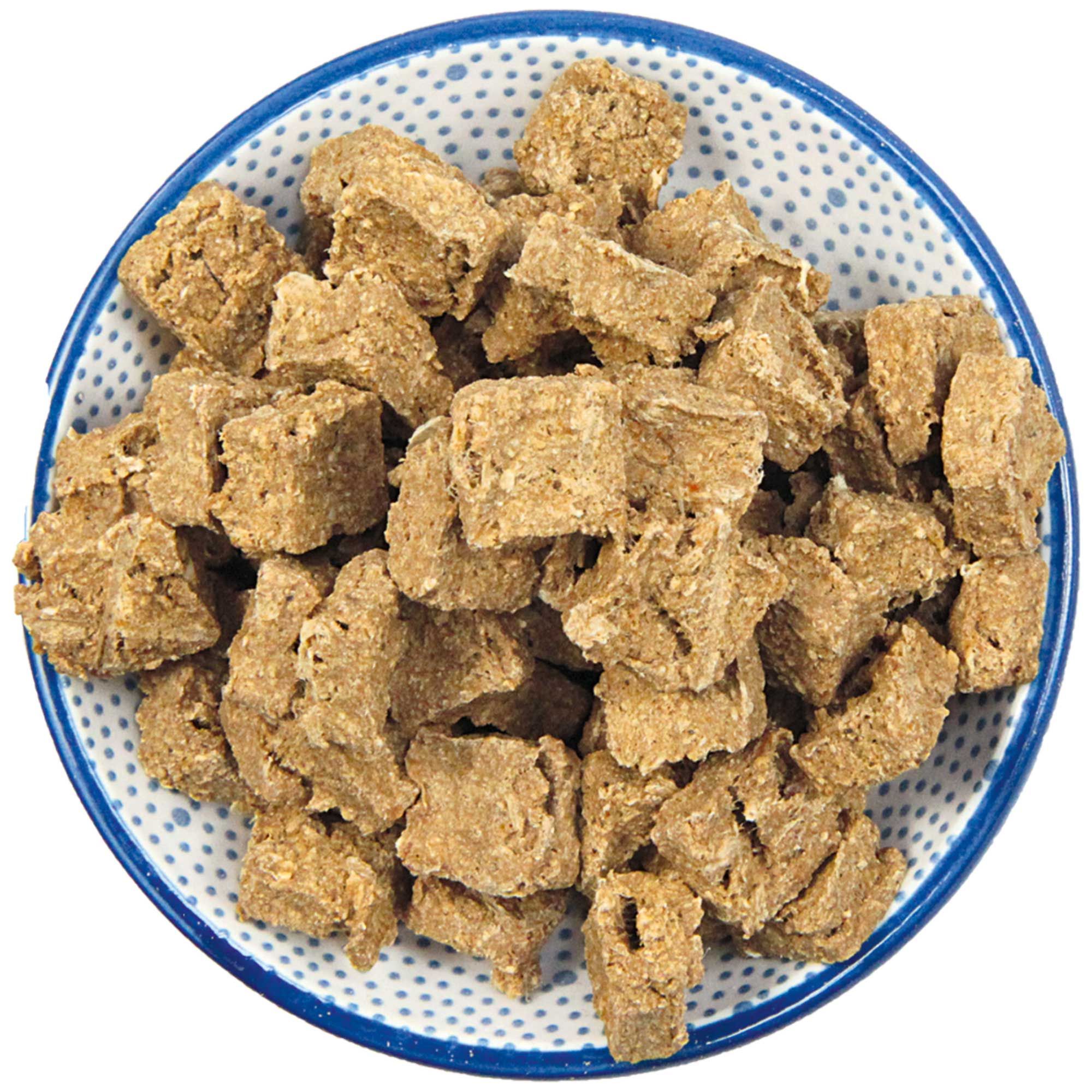 Hundefutter-Nuggets in einer Schale. Eckige, beige Stücke. Blaue Schale mit weißem Muster.