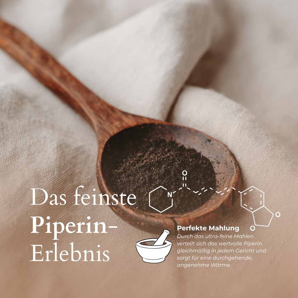 Schwarzes Pfefferpulver auf einem Holzlöffel. Chemische Strukturformel. Text: Das feinste Piperin-Erlebnis. Perfekte Mahlung.