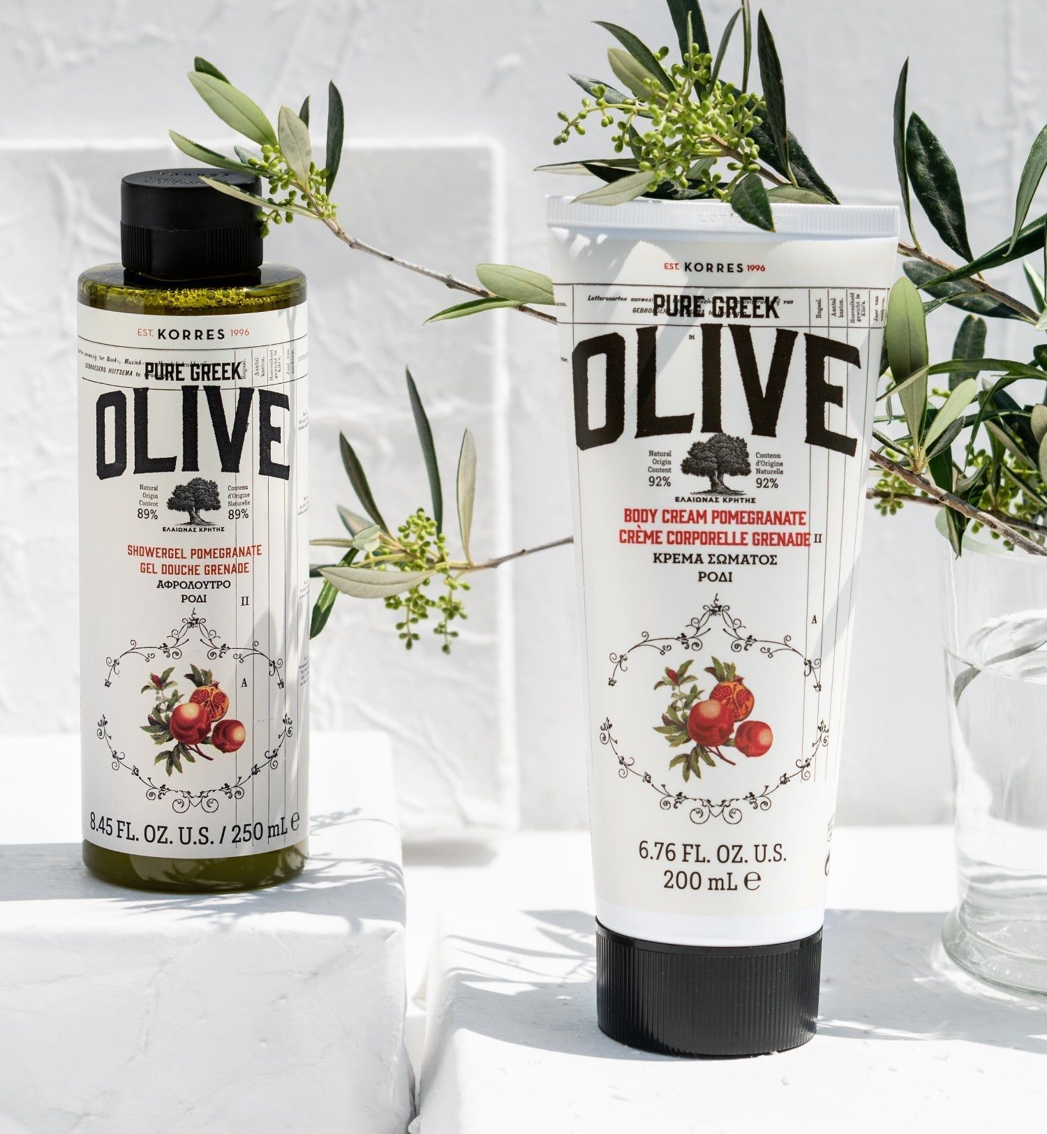 Zwei Körperpflegeprodukte: Duschgel und Körpercreme. Beide mit Oliven- und Granatapfel-Motiven. Aufschrift: KORRES Pure Greek Olive.