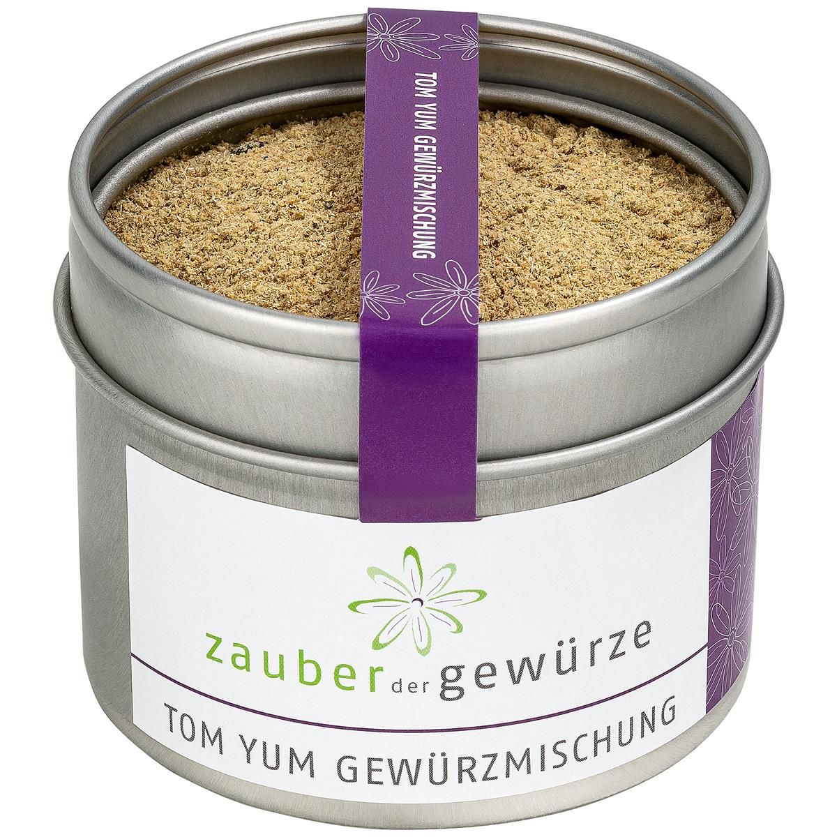 Runde Dose mit Tom Yum Gewürzmischung. Weißes Etikett mit Logo und Schriftzug 'Zauber der Gewürze Tom Yum Gewürzmischung'. Lila Band mit Text.