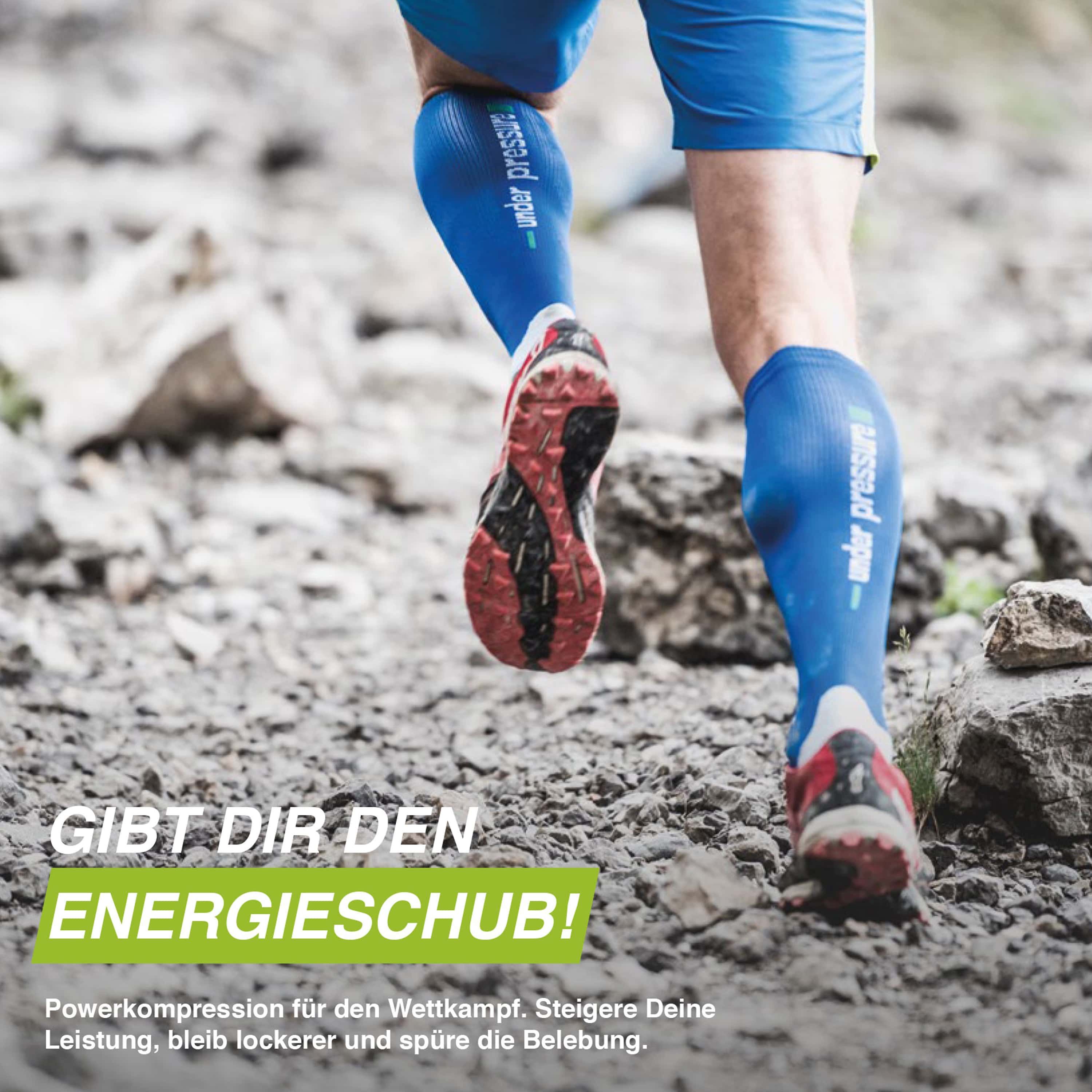 Läuferbeine mit blauen Kompressionsstrümpfen. Schriftzug "under pressure". Laufschuhe auf steiniger Oberfläche.
